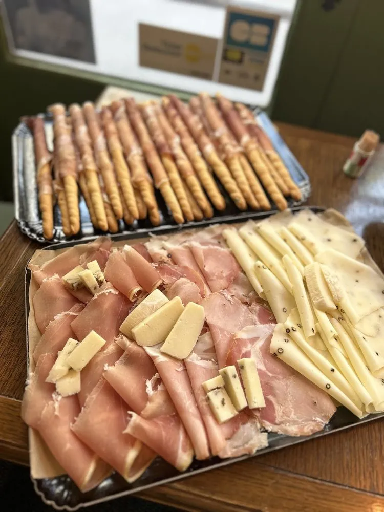 Plateau de jambon, de fromages en lamelles et de gressins enroulés de jambon